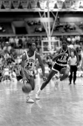 Basketball player Reggie Perkins dribbles the basketball in a game against the University of North Dakota, St. Cloud State University