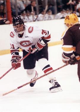 Hockey player avoids an opposing player, St. Cloud State University