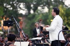 A man conducts an orchestra, Lemonade Concert and Art Fair, St. Cloud State University