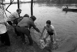 Curt Quiner climbs out of the Mississippi River after crossing it, St. Cloud State University