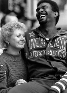 Harlem Globetrotter "Sweet" Lou Dunbar sits on the lap of Mary Schlangen, St. Cloud State University