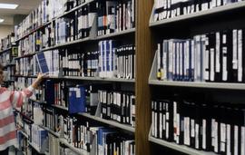 Student looks through the tape library at UTVS, St. Cloud State University