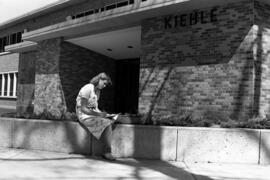 Woman sits in front of Kiehle (1952), St. Cloud State University