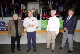 Gladys Ziemer, unidentified man, Suzanne Williams, and Morris Kurtz get ready to drop the ceremonial first puck at St. Cloud State's first women's hockey game