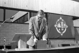 St. Cloud State president Charles Graham handles the Administrative Services (1975) time capsule for the cornerstone at the building's dedication