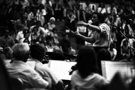 A man conducts an orchestra, Lemonade Concert and Art Fair, St. Cloud State University