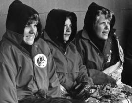 Collette Hatle, Courtney Miller, and Dawn Kleine keep warm during a softball game, St. Cloud State University