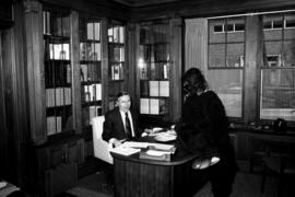 President Charles Graham visited by a gorilla in his Whitney House office, St. Cloud State University