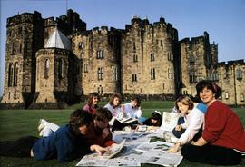 Students read the paper on the lawn at Alnwick, St. Cloud State University