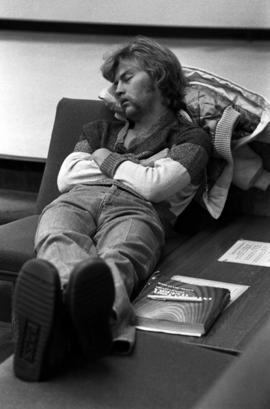 Student sleeps in Centennial Hall (1971) during finals week, St. Cloud State University