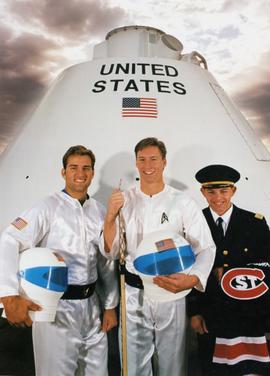 Tim Hanus, Jeff Saterdalen, and Doc DelCastillo pose in front of a space capsule, St. Cloud State University