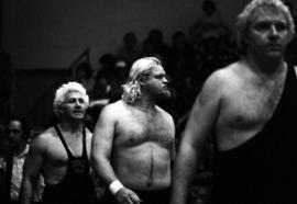 Ken Patera, Bobby Duncum, and Bobby Heenan walk to the ring before a wrestling match at Halenbeck Hall (1965), St. Cloud State University