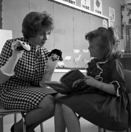 Adelle Nally, a student teacher, shows two puppets to a child, St. Cloud State University