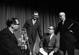 Four men stand and sit together, St. Cloud State University