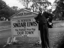 Sinclair Lewis stands in front of a sign advertising the play Our Town
