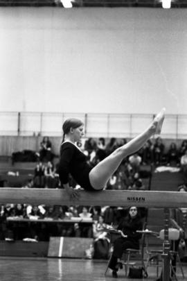 Woman gymnast competes on the balance beam in a meet against the University of Wisconsin-River Falls, St. Cloud State University