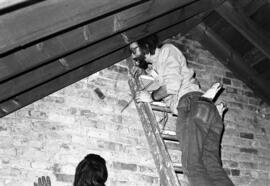 David Mork looks for bats in the attic of Riverview (1913), St. Cloud State University