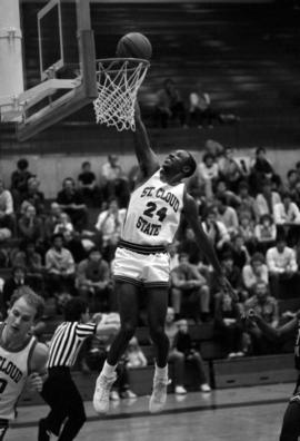 Basketball player Reggie Perkins dunks a basketball during a game against the University of Minnesota-Morris, St. Cloud State University