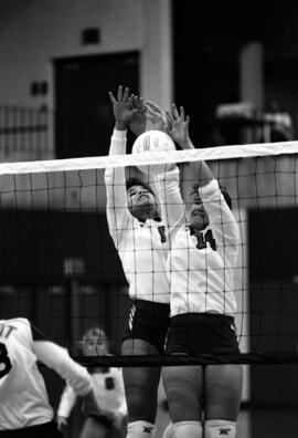 Kathy Davis and a teammate block a volleyball during a volleyball match against the University of Wisconsin - Stout, St. Cloud State University