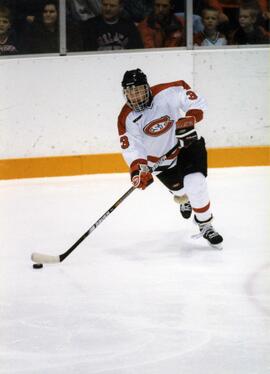 Geno Parrish handles the puck during a hockey game, St. Cloud State University