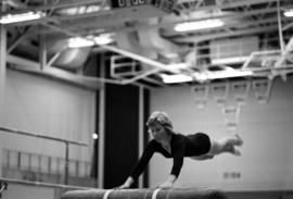 Woman gymnast competes in a meet against the University of Wisconsin-River Falls, St. Cloud State University