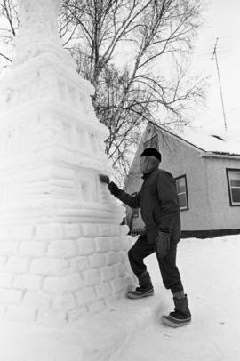 Artist Larry Saatzer works on a Statue of Liberty snow sculpture