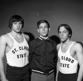 Wrestling coach John Oxton with two wrestlers, St. Cloud State University