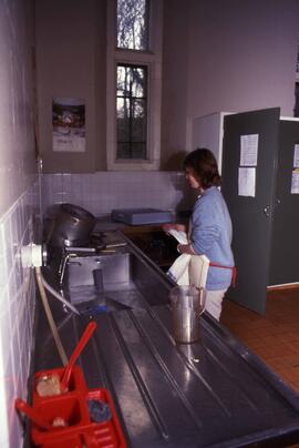 Student washes dishes in a kitchen, Alnwick Castle, St. Cloud State University