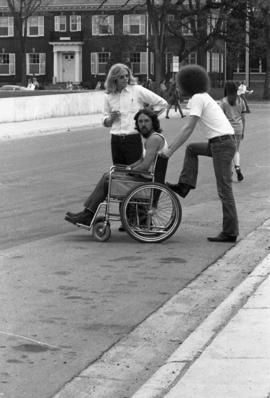 A man is pushed in a wheelchair, Day of Peace protest, St. Cloud State University