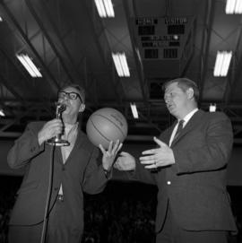 Ed Colletti presents St. Cloud State men's basketball coach Marlowe "Red" Severson with the game ball after St. Cloud State defeated Bemidji State, giving Severson his 200th victory at St. Cloud State