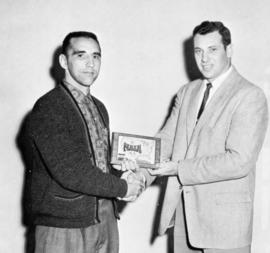 Monte Sinner receives his first place trophy from St. Cloud State University wrestling coach Willis Wood