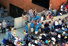 People gather on sidewalks to watch an orchestra perform, Lemonade Concert and Art Fair, St. Cloud State University