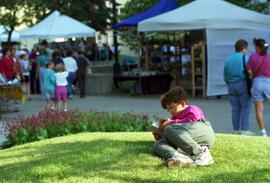 A boy lays on the lawn and reads a book, Lemonade Concert and Art Fair, St. Cloud State University