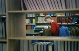 Woman looks at reference books at Centennial Hall (1971), St. Cloud State University