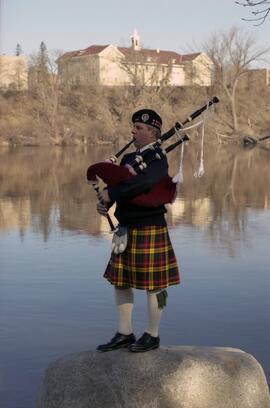 Ben Richason plays bagpipes on the shores of the Mississippi River, St. Cloud State University