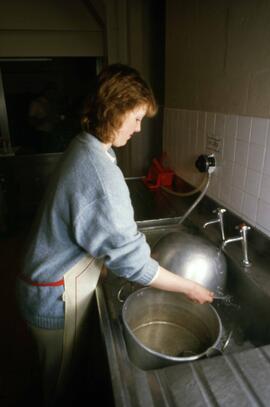 Student washes dishes in a kitchen, Alnwick Castle, St. Cloud State University