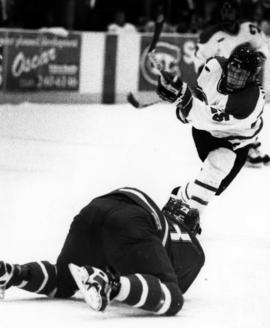 Tom Lund shots a puck during a hockey game, St. Cloud State University