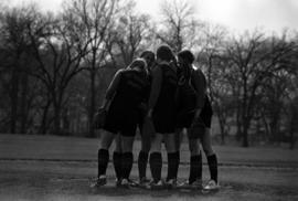 Women confer during a softball game against Bethel College, St. Cloud State University