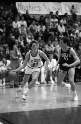 Basketball player Kevin Treanor dribbles a basketball during a game against Morningside College , St. Cloud State University