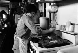 Ginny Peterson cooks hamburgers at the Flat Iron Bar, St. Cloud