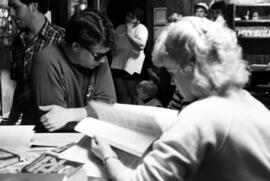 A woman searches through a book, KVSC trivia weekend, St. Cloud State University