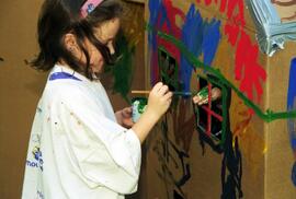 A girl paints a cardboard house, Lemonade Concert and Art Fair, St. Cloud State University