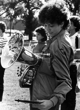 A woman looks at sheet music while practicing for the marching band