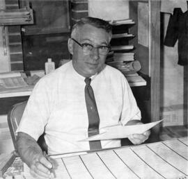 Ed Colletti sits at a desk, St. Cloud State University