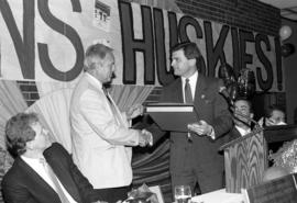 Jeff Passolt gives an award to Charlie Basch at the hockey banquet, St. Cloud State University