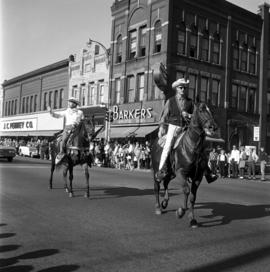 St. Cloud State president George Budd and another man ride horses in the homecoming parade