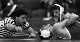 Wrestler Kermit Hanson lies on the mat against another wrestler, St. Cloud State University