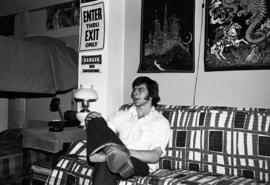 A student sits on a couch in his dormitory room, St. Cloud State University