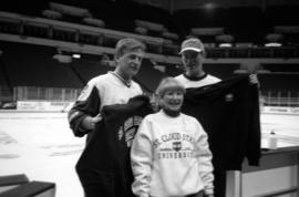 Jeff Passolt and Richard Dean Anderson with a woman at the St. Cloud State celebrity hockey game at Target Center