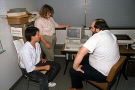 Group gathers around computer, St. Cloud State University